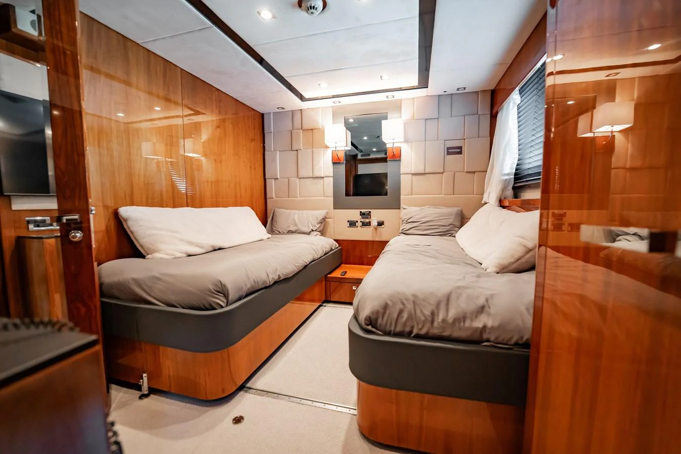 The guest stateroom features twin beds with luxurious bedding and warm wood paneling. aboard BLUE Yacht for Sale