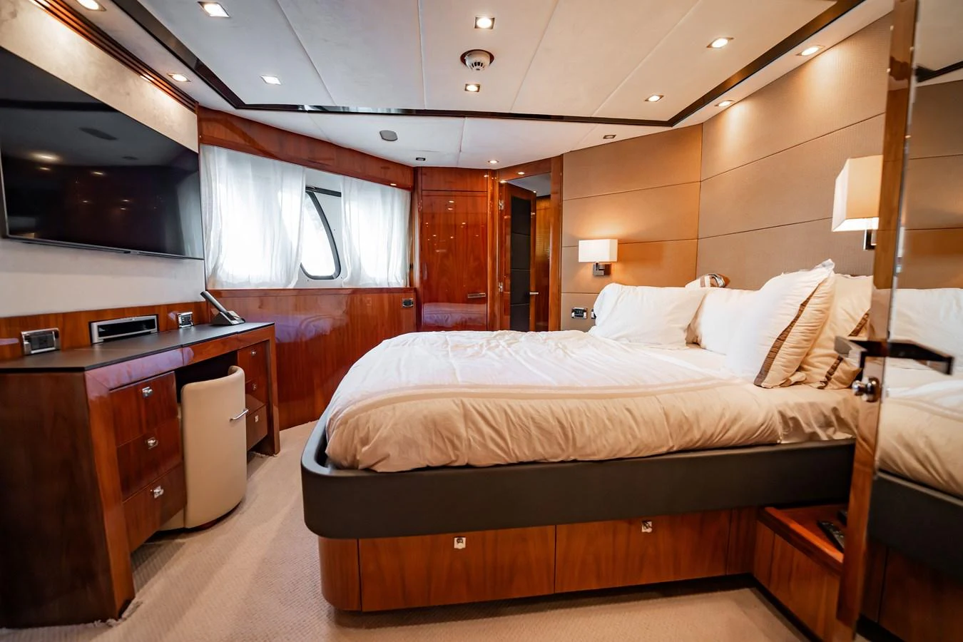 The master stateroom features a luxurious bed, ample natural light, and elegant wood finishes. aboard BLUE Yacht for Sale