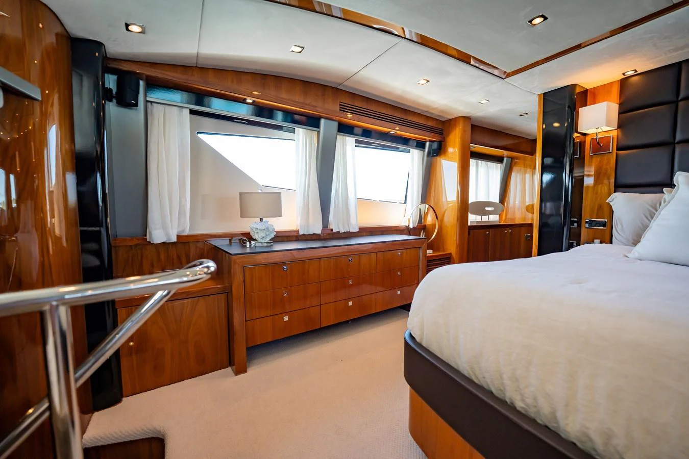 The stateroom features elegant wood paneling, plush bedding, and ample natural light from large windows. aboard BLUE Yacht for Sale