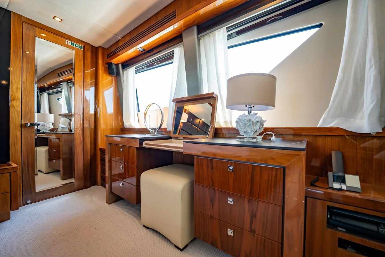 The yacht's stateroom features elegant wooden cabinetry, a vanity desk, and large windows for natural light. aboard BLUE Yacht for Sale