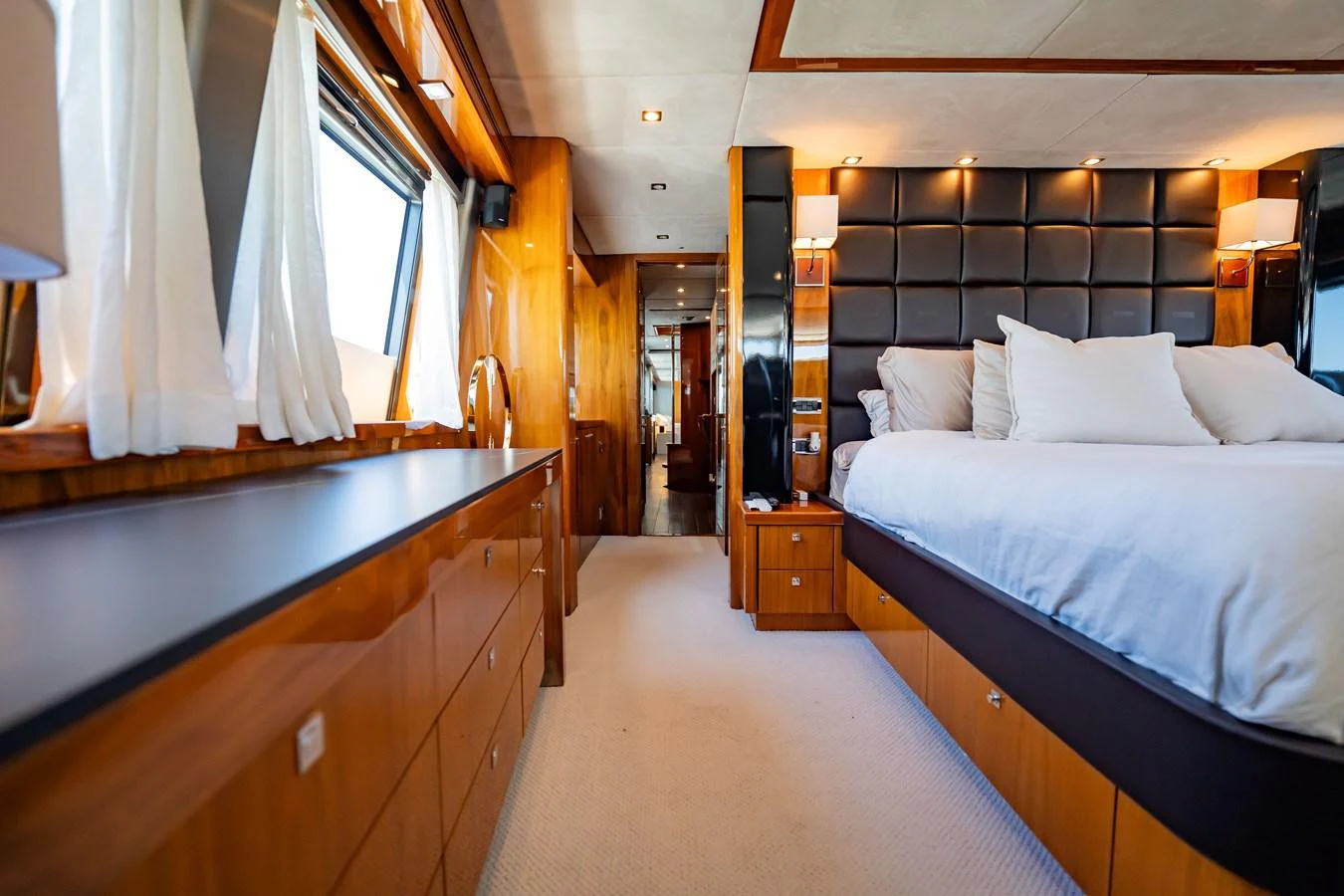 The master stateroom features luxurious bedding and elegant wood finishes, creating a serene and sophisticated retreat. aboard BLUE Yacht for Sale