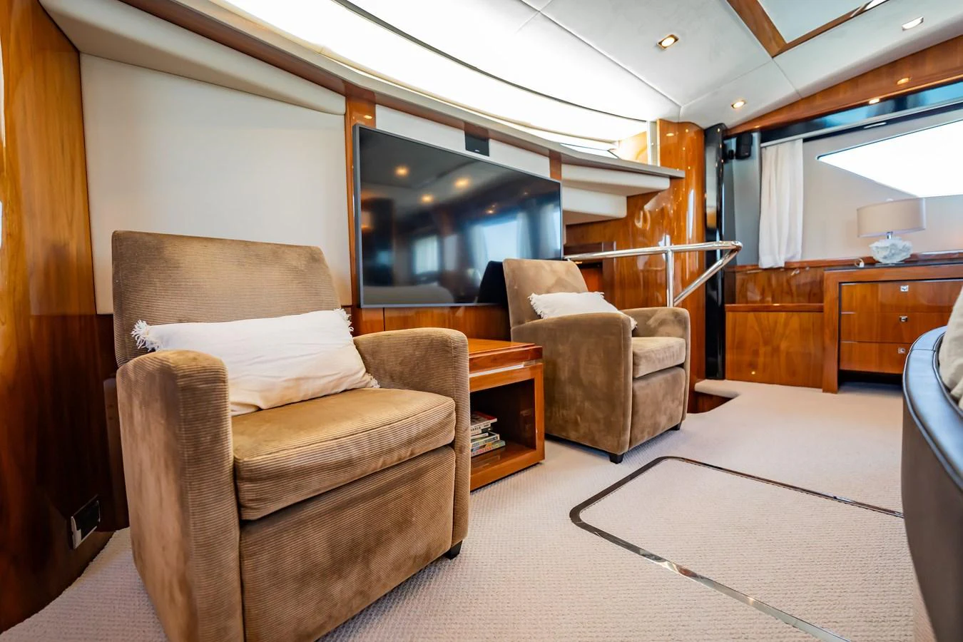 The yacht's interior features a cozy seating area with plush armchairs and a large television. aboard BLUE Yacht for Sale