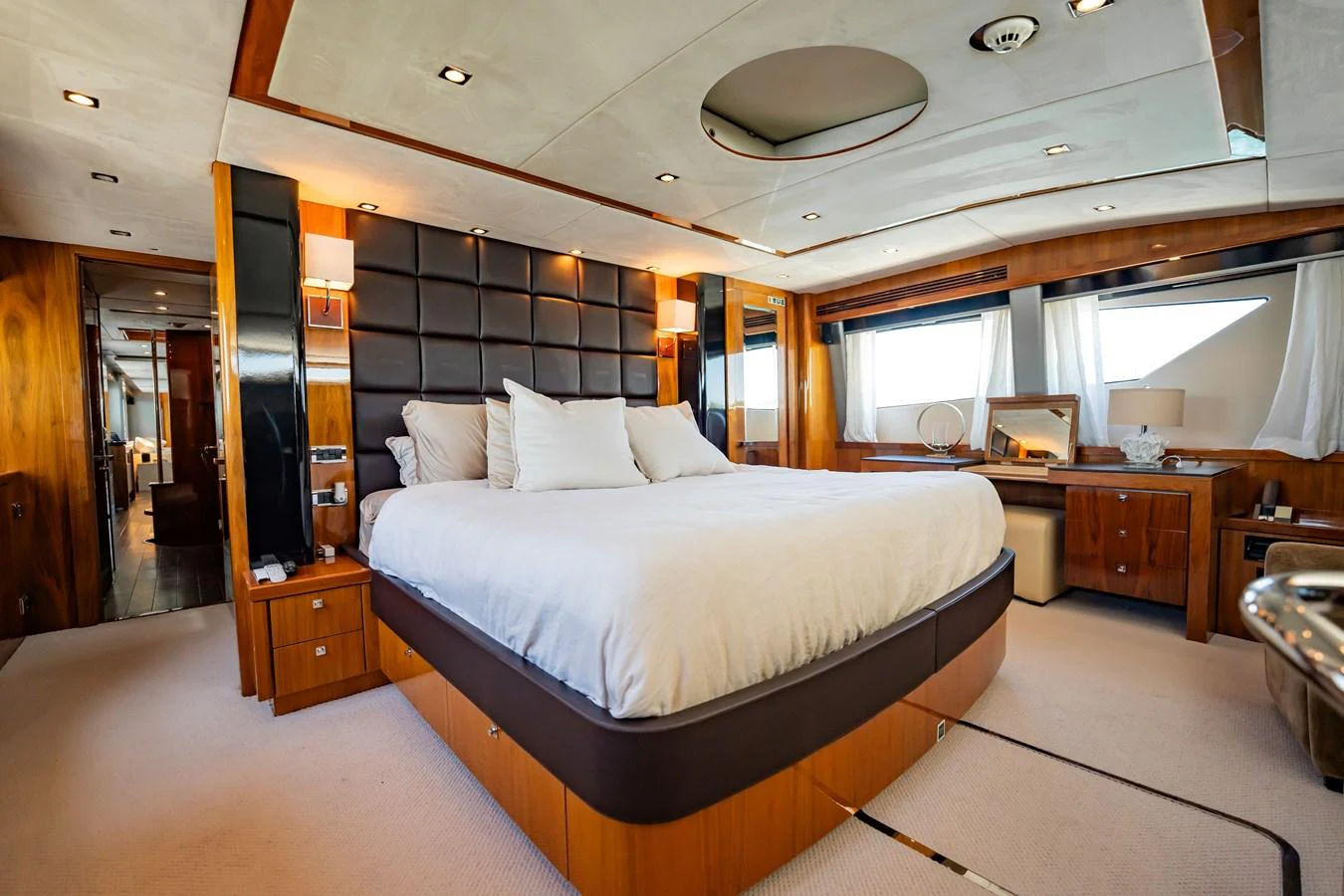 The master stateroom features a luxurious bed with plush pillows and elegant wood finishes. aboard BLUE Yacht for Sale