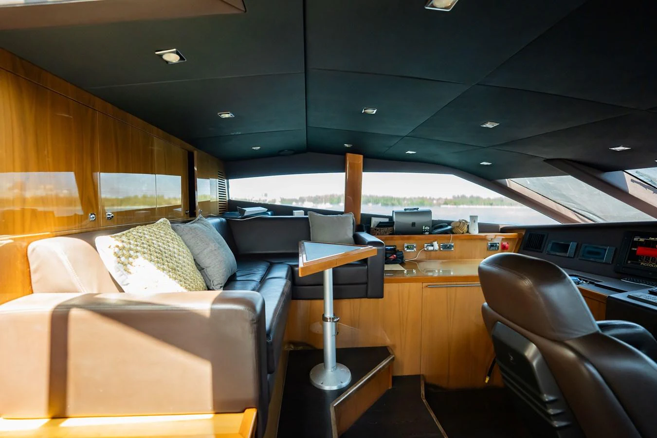 The helm area features a comfortable seating arrangement with a modern control console and panoramic views. aboard BLUE Yacht for Sale