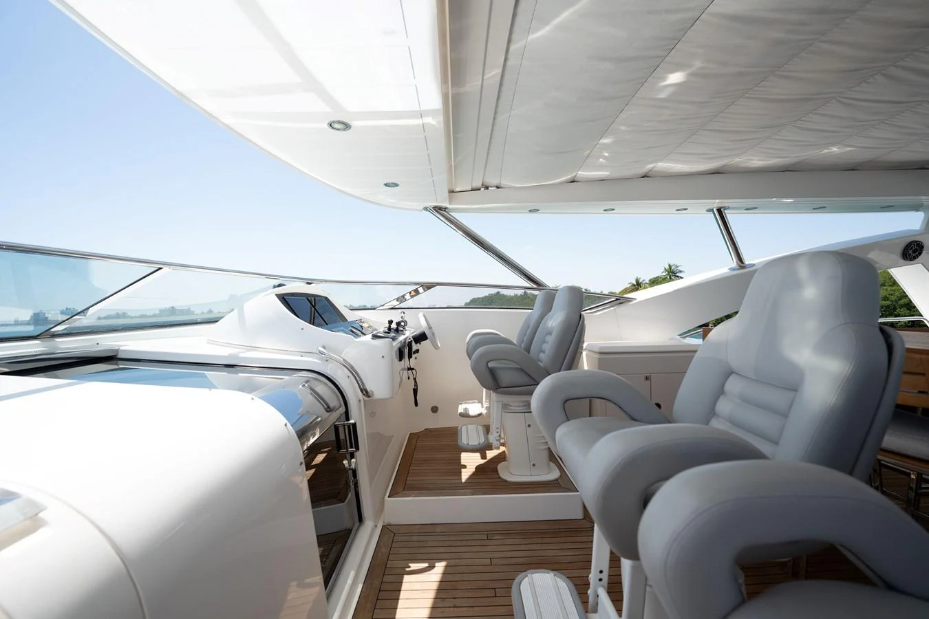 The helm area features plush seating and a sleek control console under a shaded canopy. aboard BLUE Yacht for Sale
