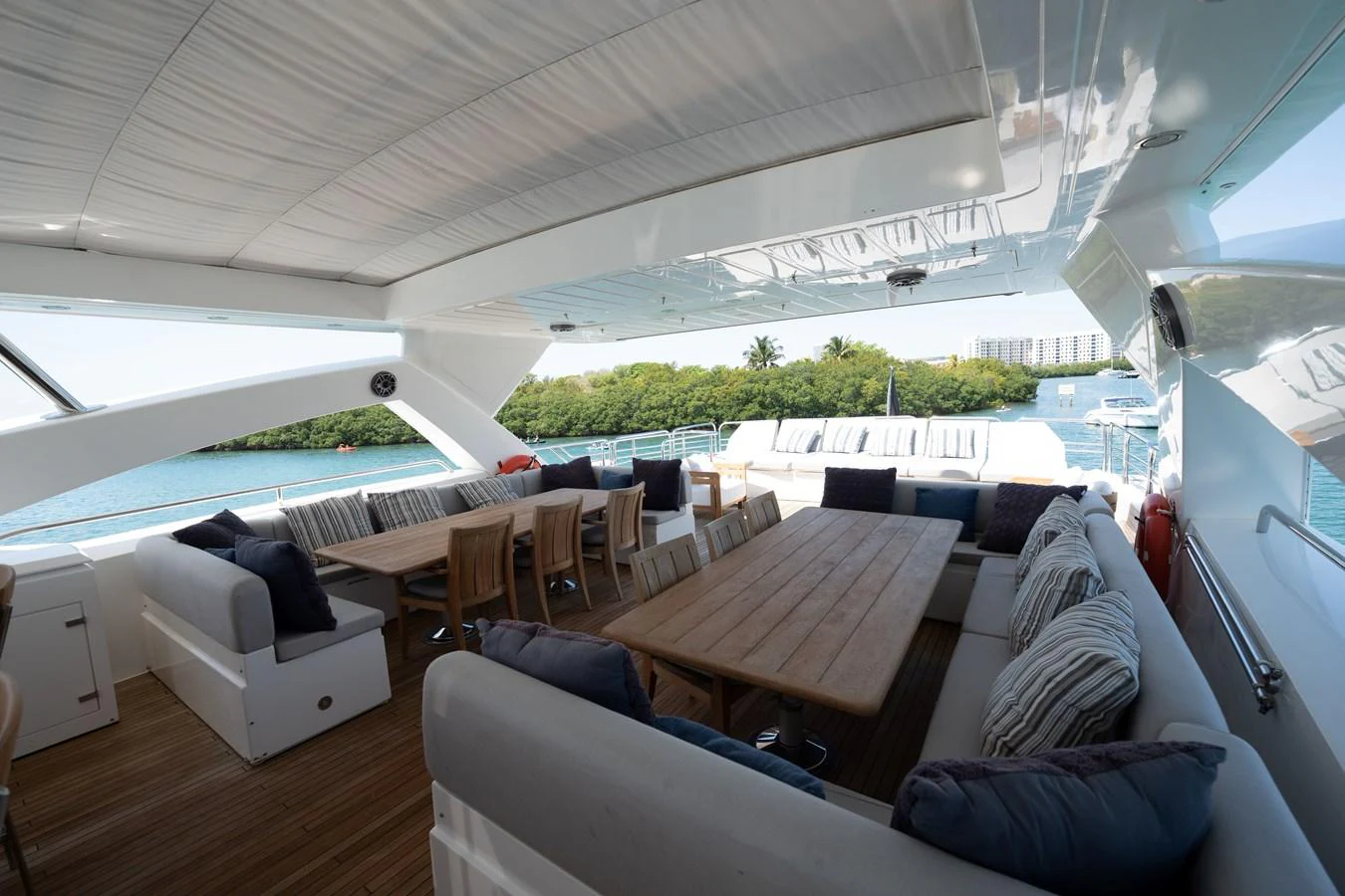 The aft deck features a spacious seating area with a large dining table, perfect for alfresco dining and relaxation. aboard BLUE Yacht for Sale