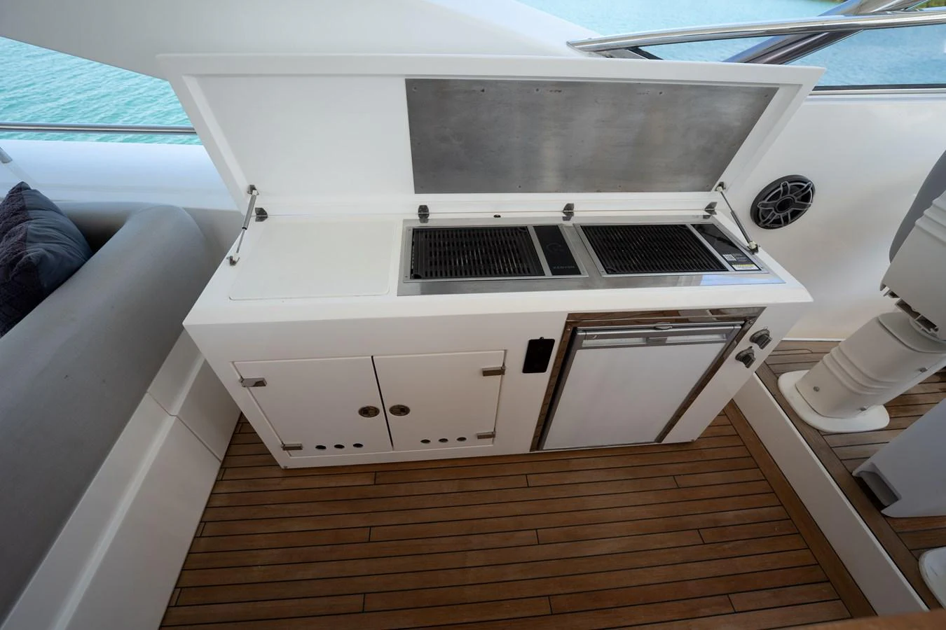 This image showcases a sleek outdoor galley with a grill and mini-fridge, perfect for alfresco dining. aboard BLUE Yacht for Sale