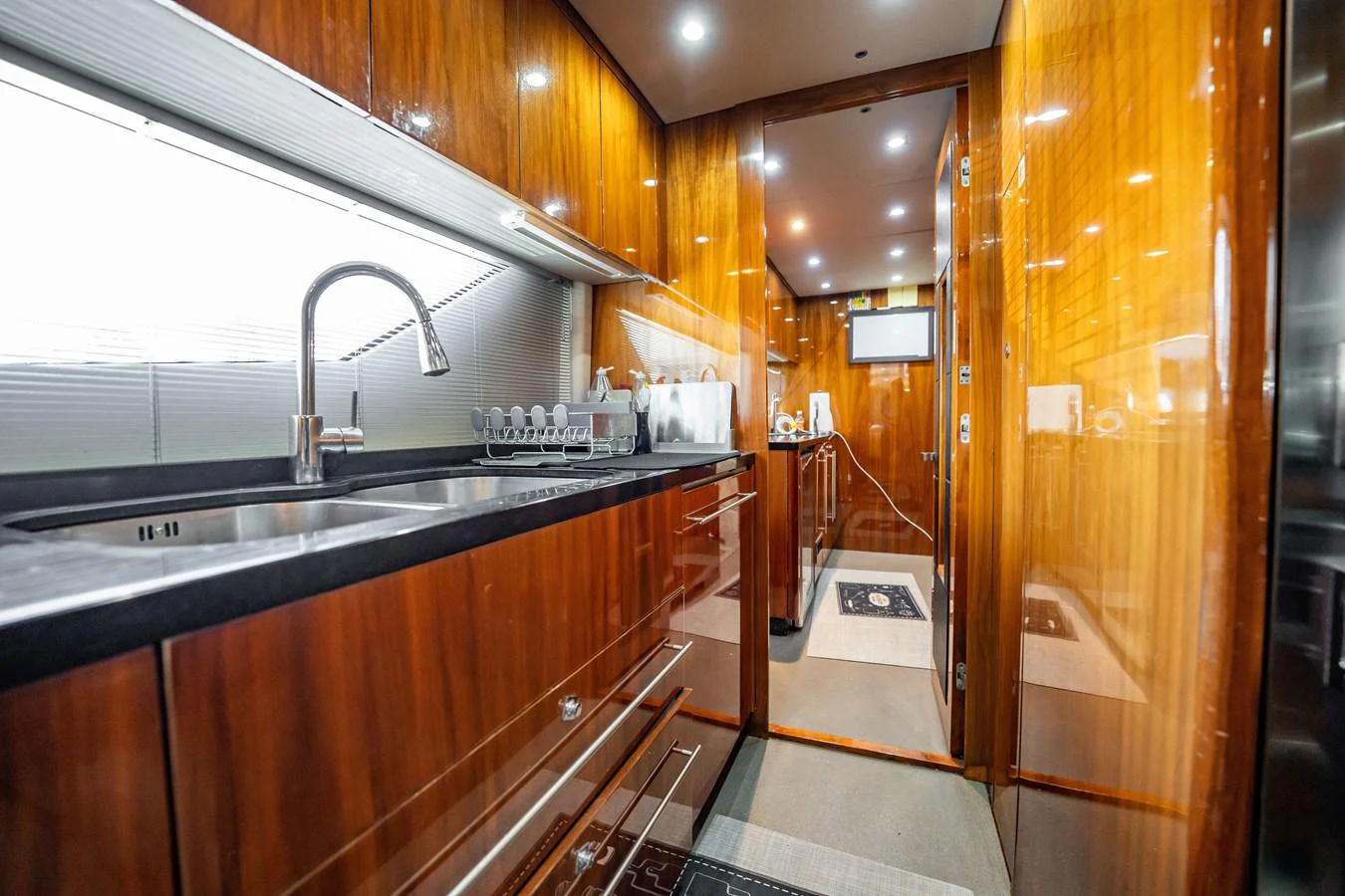 The yacht's galley features sleek wooden cabinetry, modern appliances, and ample counter space. aboard BLUE Yacht for Sale