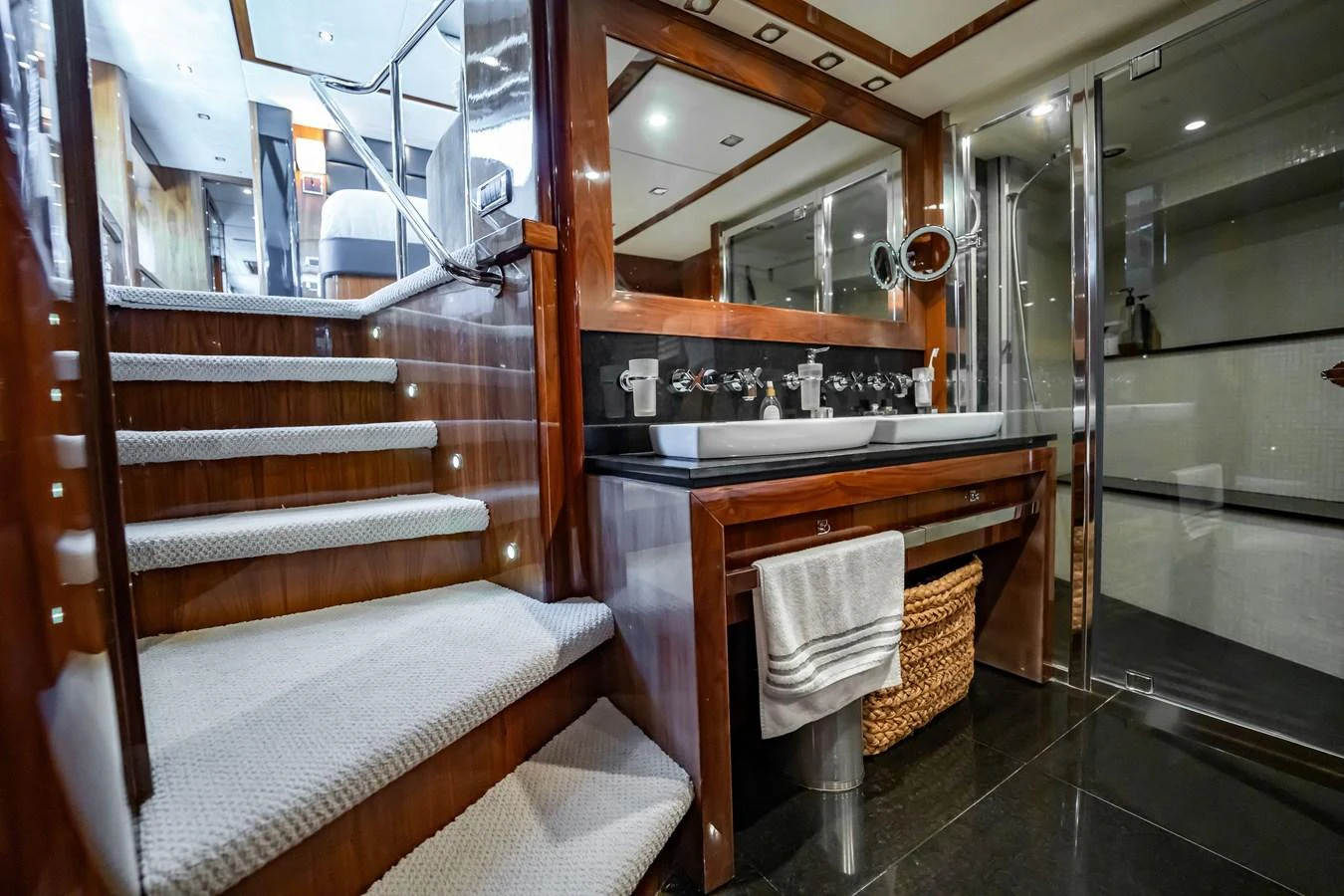 The yacht's interior features a modern bathroom with a double sink vanity and a staircase leading to another level. aboard BLUE Yacht for Sale