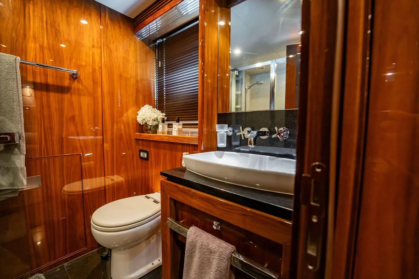 A luxurious yacht bathroom featuring rich wood paneling and modern fixtures. aboard BLUE Yacht for Sale