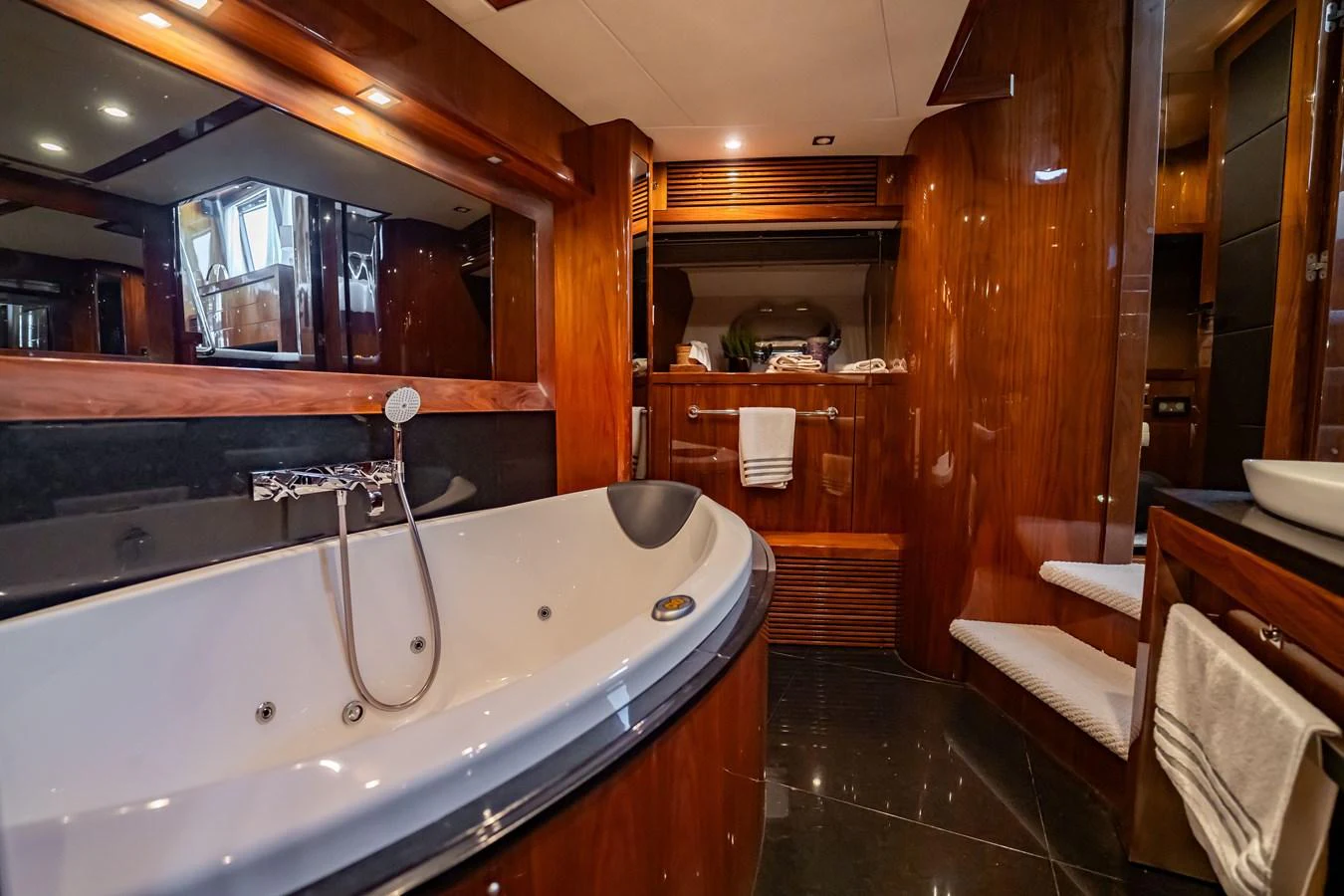 The luxurious bathroom features a spacious bathtub and elegant wooden finishes. aboard BLUE Yacht for Sale