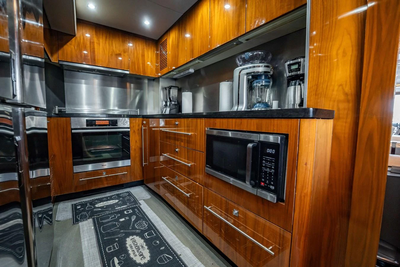 The yacht's galley features modern appliances and rich wood cabinetry, creating a warm and functional space. aboard BLUE Yacht for Sale