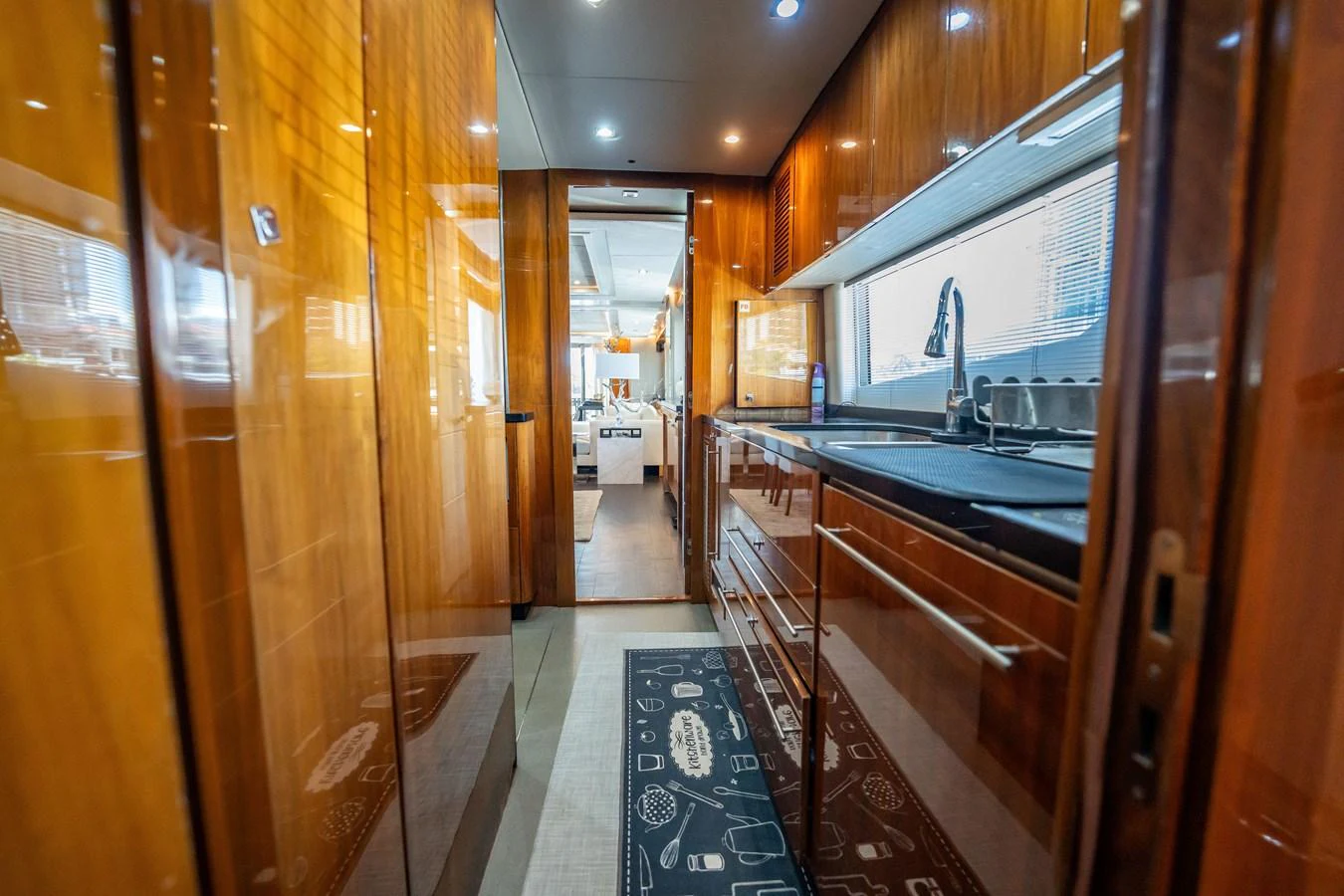 The galley features sleek wooden cabinetry and modern appliances, creating a warm and inviting space for culinary activities. aboard BLUE Yacht for Sale