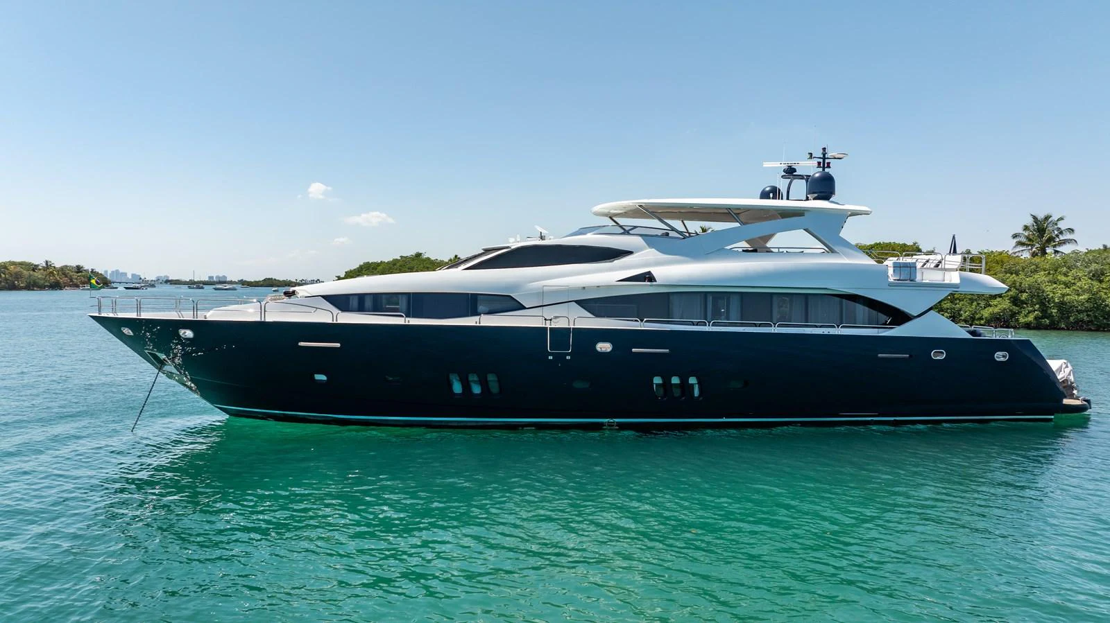 A sleek and modern yacht glides gracefully on calm turquoise waters under a clear blue sky. aboard BLUE Yacht for Sale
