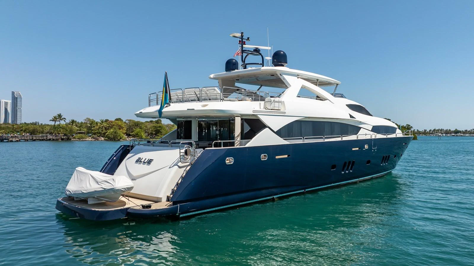 A sleek and modern yacht with a dark blue hull and white superstructure cruising on calm waters. aboard BLUE Yacht for Sale