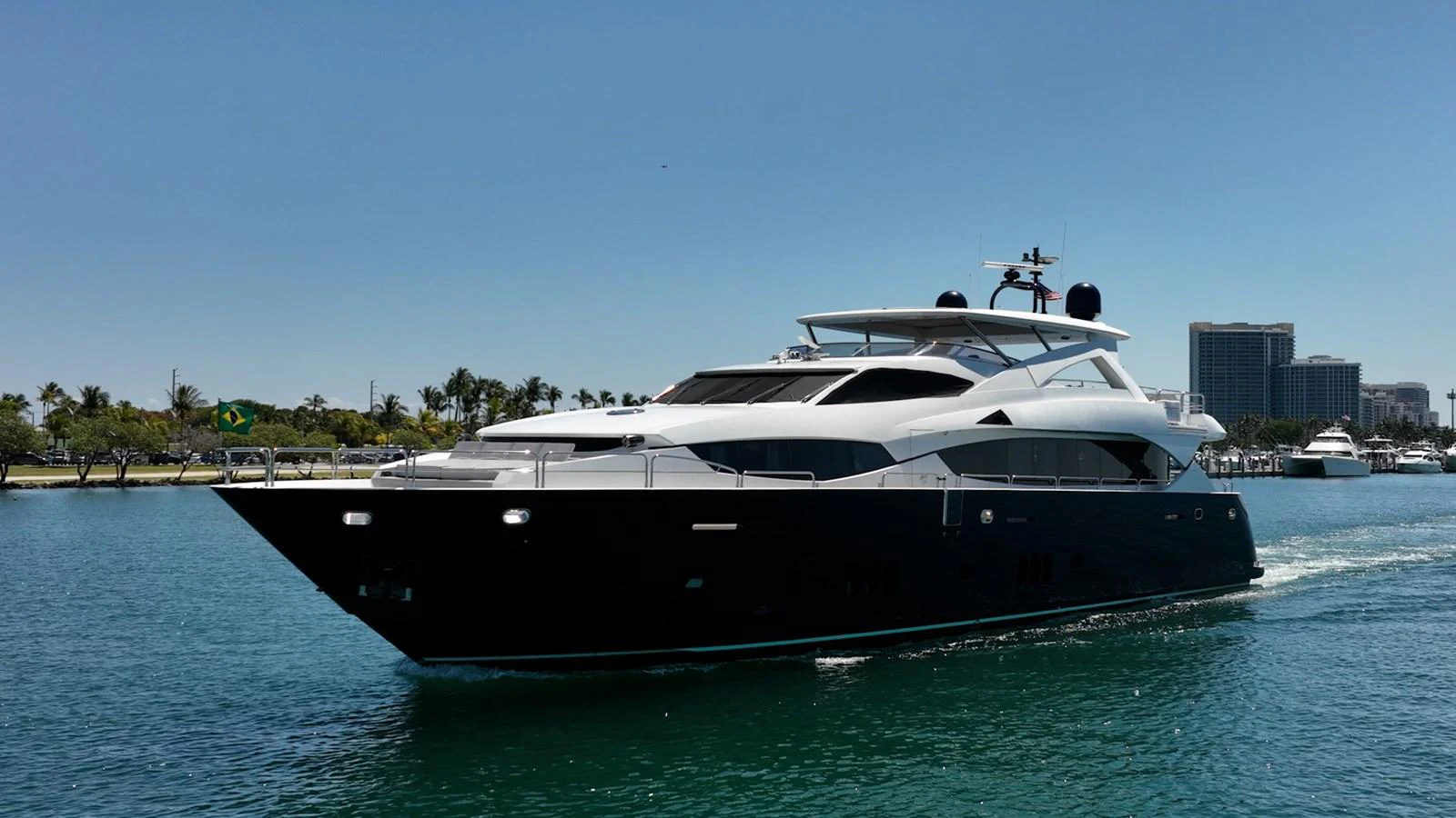 A sleek and modern yacht cruises through calm waters under a clear blue sky. aboard BLUE Yacht for Sale