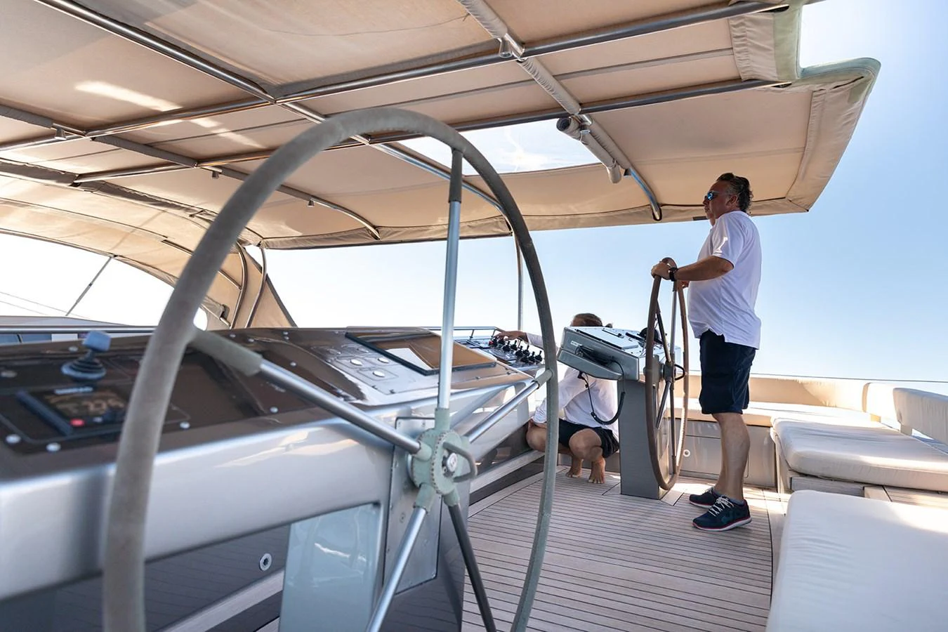 The helm station features a spacious and shaded area with modern navigation equipment and comfortable seating. aboard 4K Yacht for Sale