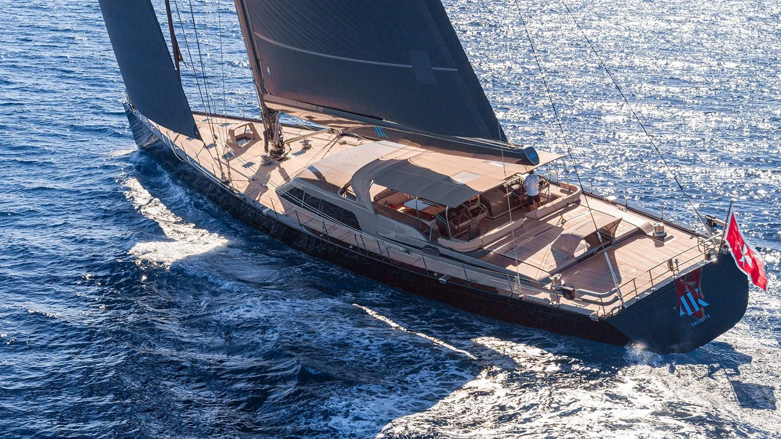 A sleek sailing yacht glides effortlessly over the sparkling blue waters. aboard 4K Yacht for Sale