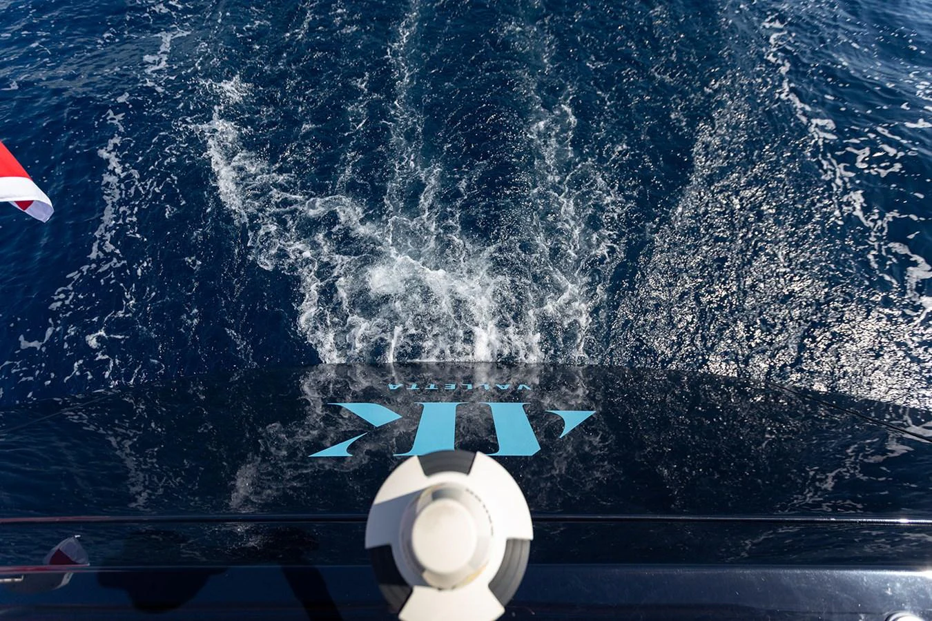 A close-up view of the yacht's stern with water turbulence behind it. aboard 4K Yacht for Sale