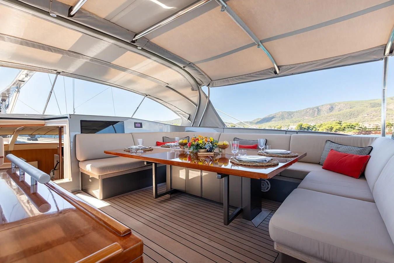 The aft deck features a spacious and elegantly set dining area under a shaded canopy. aboard 4K Yacht for Sale