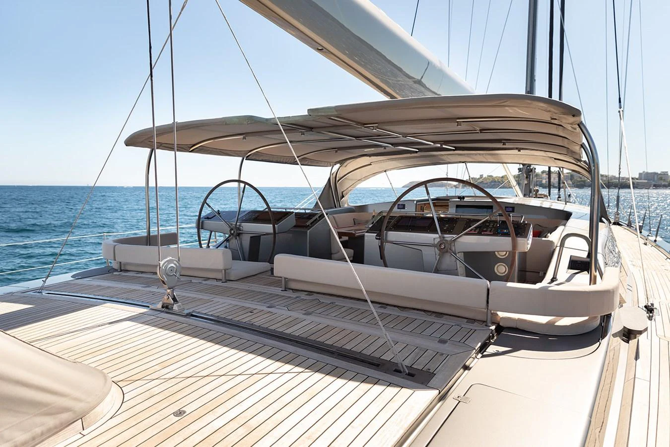 The aft deck of this yacht features elegant twin helm stations and a spacious, teak-lined lounging area. aboard 4K Yacht for Sale