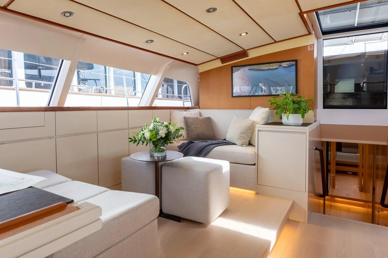 The salon features a cozy seating area with modern decor and ample natural light. aboard 4K Yacht for Sale