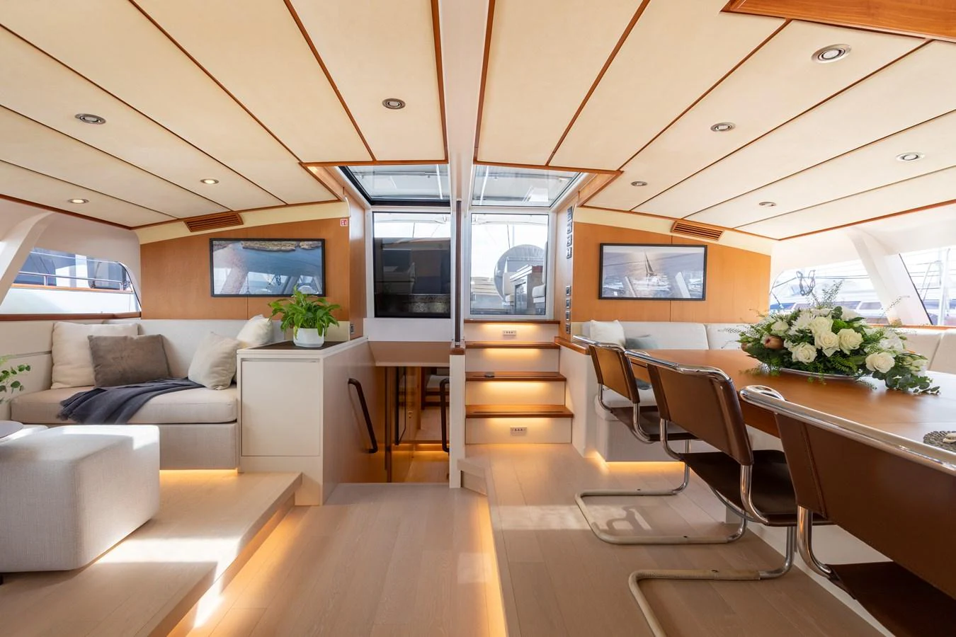 The salon features a spacious and elegantly designed seating and dining area with ample natural light. aboard 4K Yacht for Sale