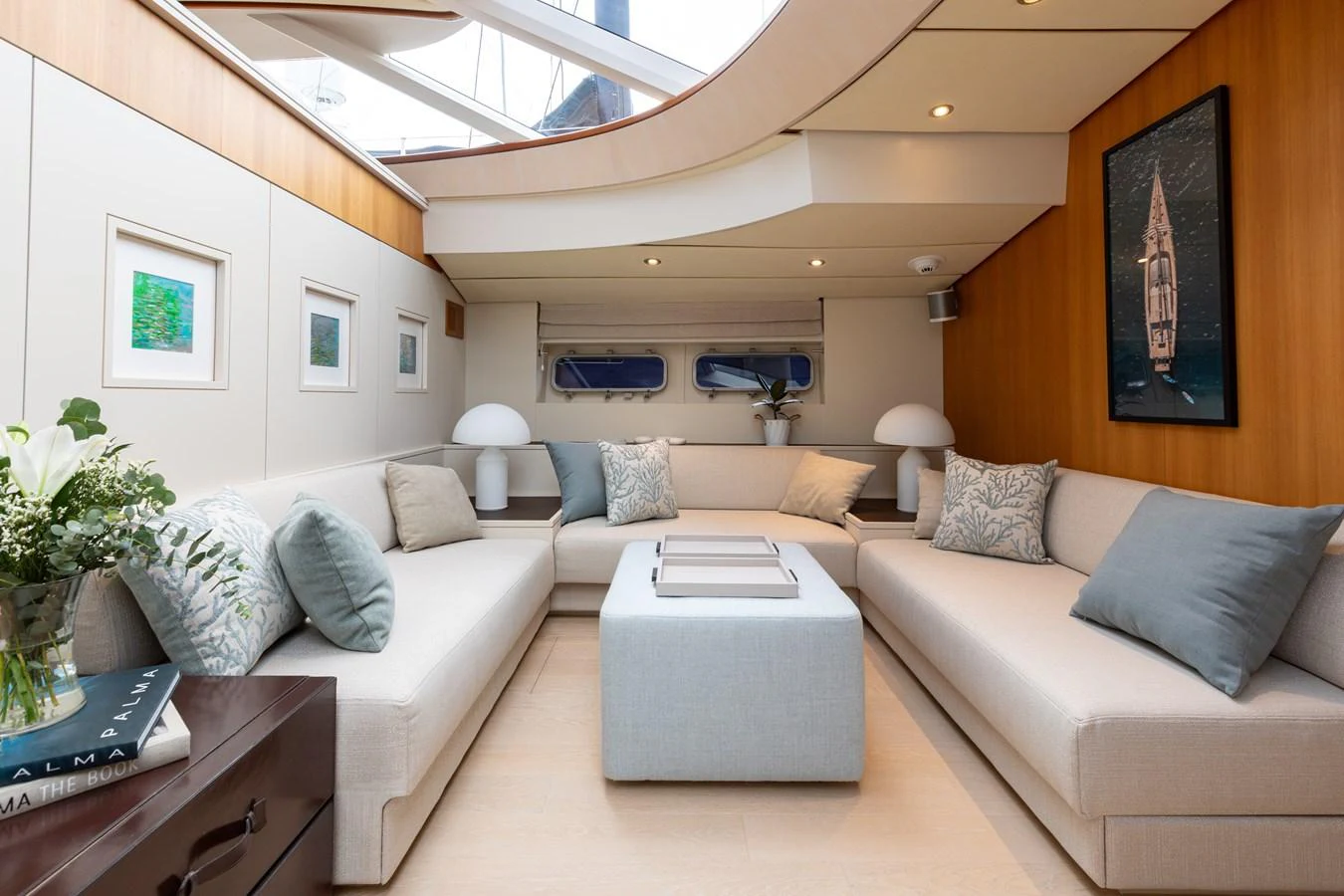 The salon features plush seating, elegant decor, and ample natural light from overhead windows. aboard 4K Yacht for Sale