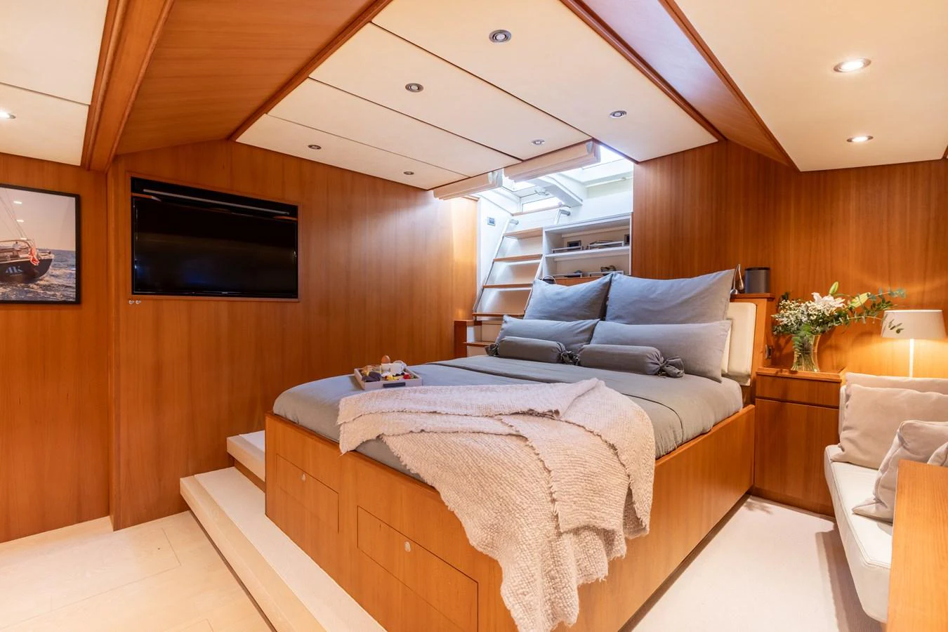 The stateroom features a cozy bed with plush bedding and warm wooden accents, creating a serene and inviting atmosphere. aboard 4K Yacht for Sale