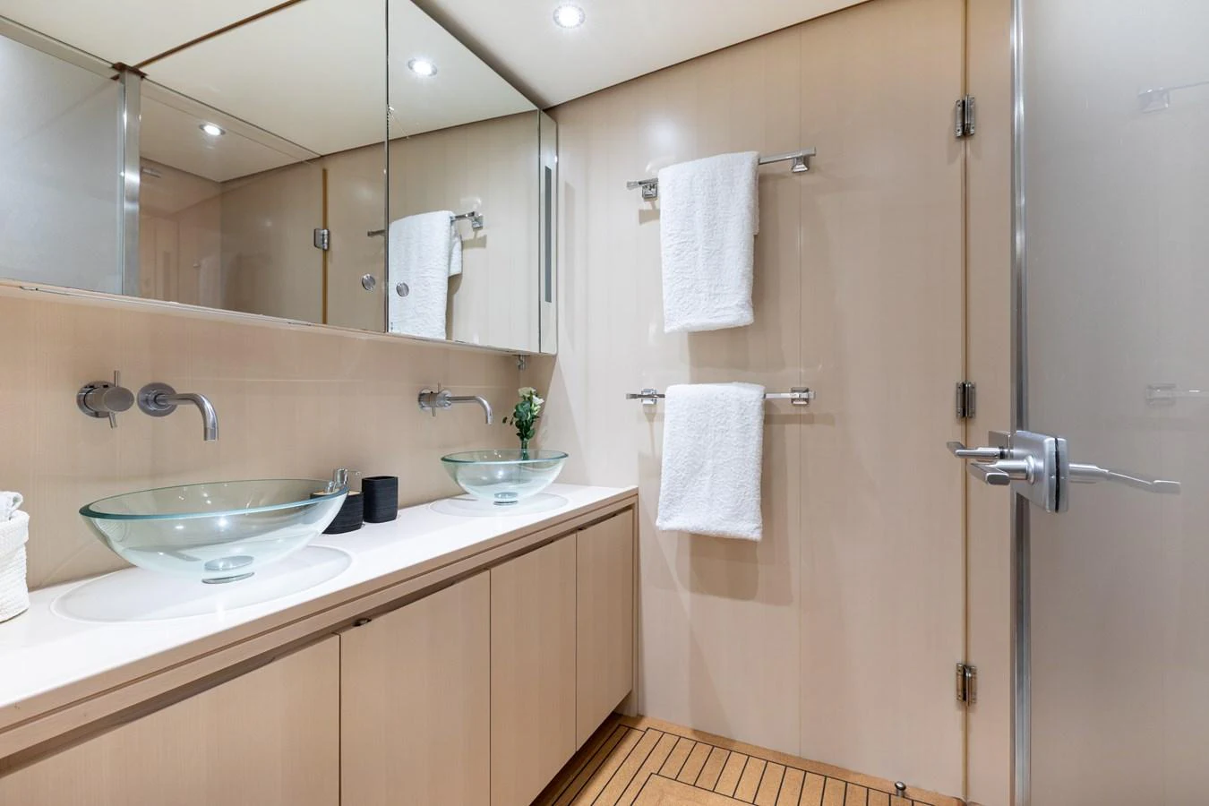 The yacht's bathroom features modern fixtures, double glass sinks, and elegant wood flooring. aboard 4K Yacht for Sale