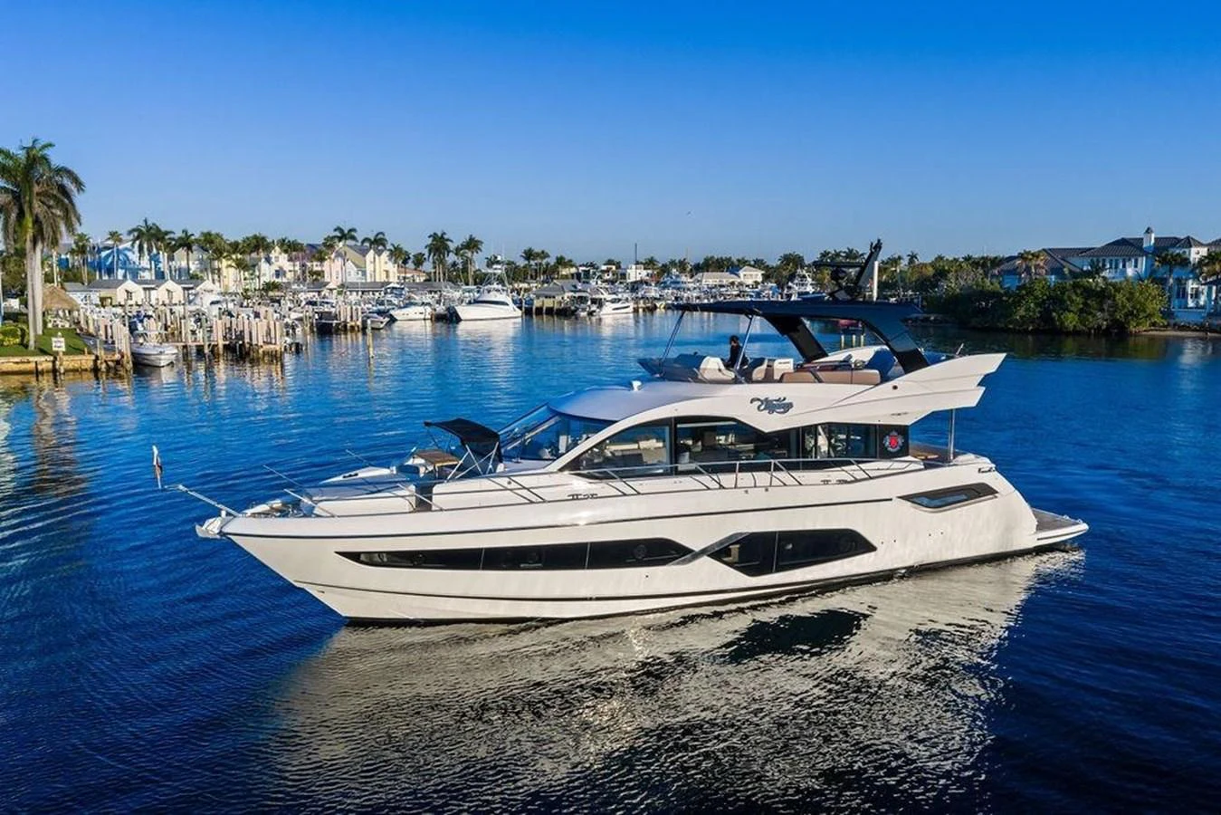 A sleek and modern yacht glides gracefully on calm waters in a picturesque marina setting. aboard ELLIGANCE Yacht for Sale