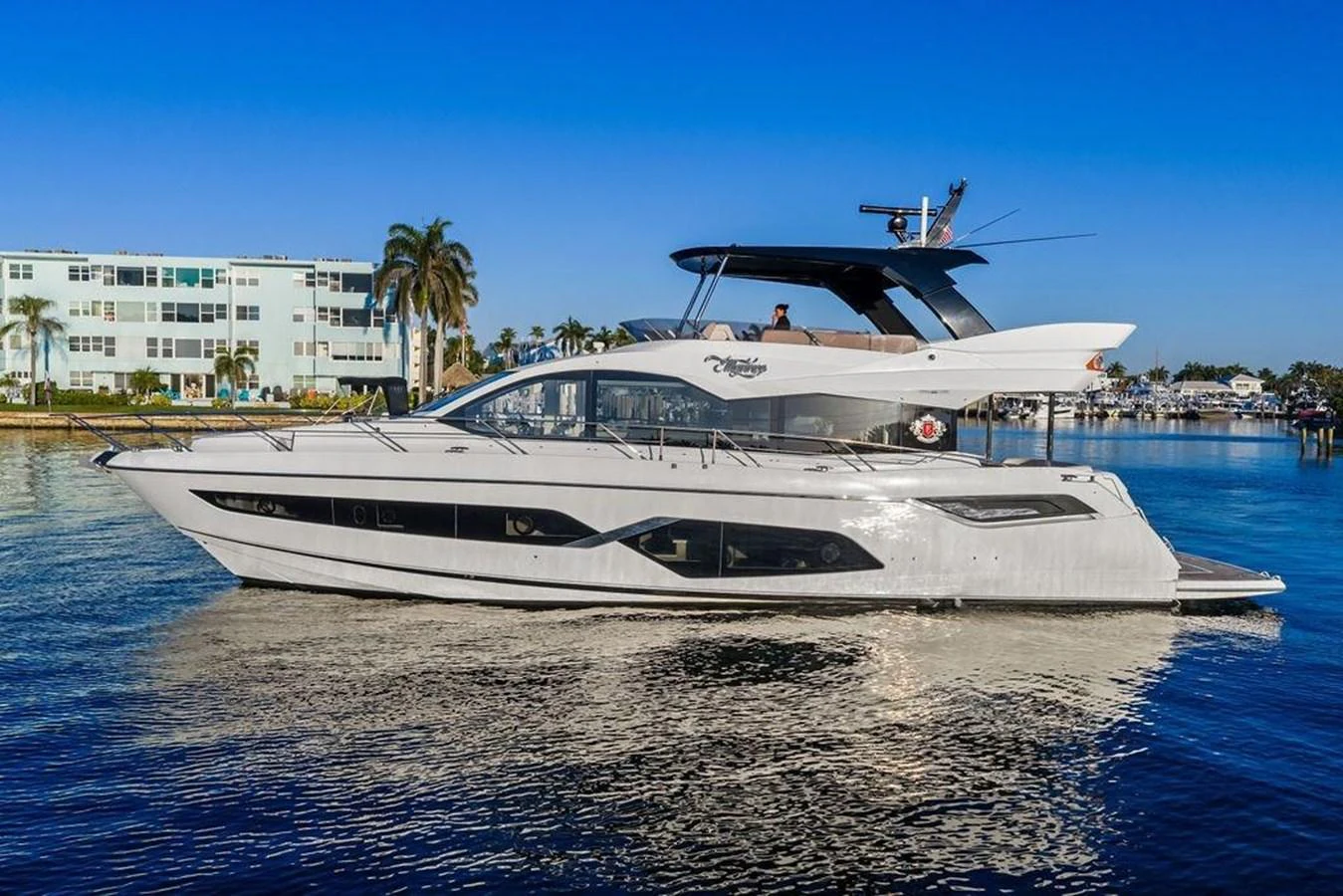A sleek, modern yacht glides gracefully on calm waters with a clear blue sky in the background. aboard ELLIGANCE Yacht for Sale