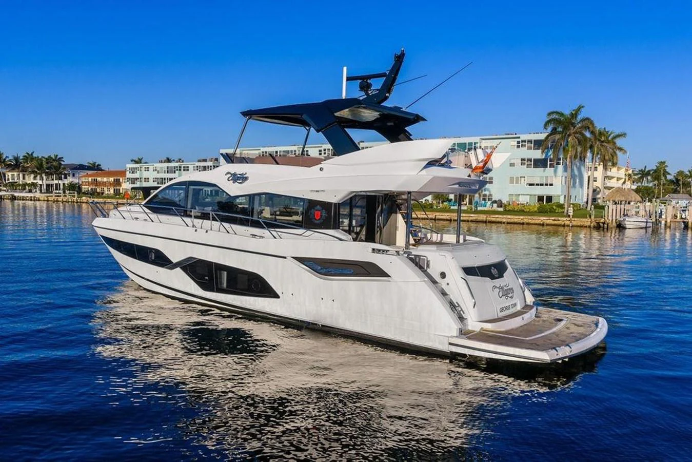 A sleek and modern yacht cruising near a coastal area with clear blue skies. aboard ELLIGANCE Yacht for Sale