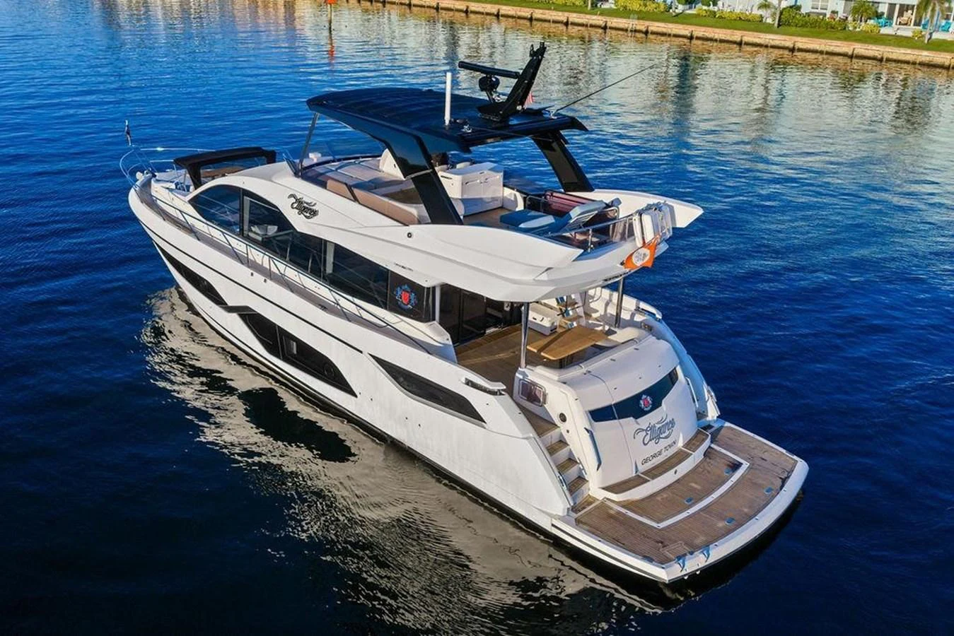 A sleek and modern yacht cruising on calm waters, showcasing its elegant design and spacious deck areas. aboard ELLIGANCE Yacht for Sale