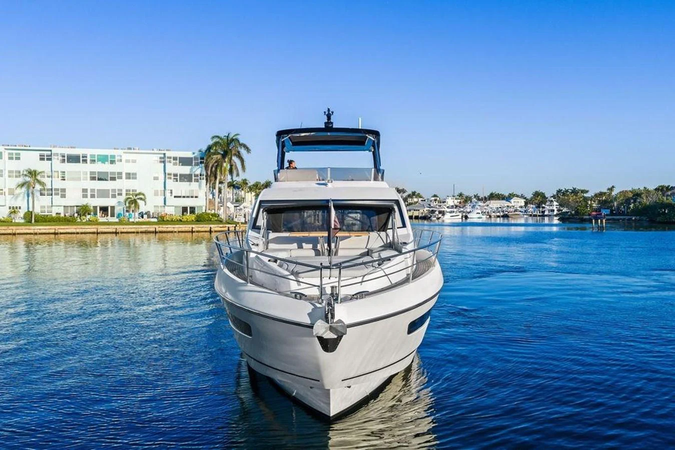 A sleek yacht glides on calm waters with a picturesque coastal backdrop. aboard ELLIGANCE Yacht for Sale