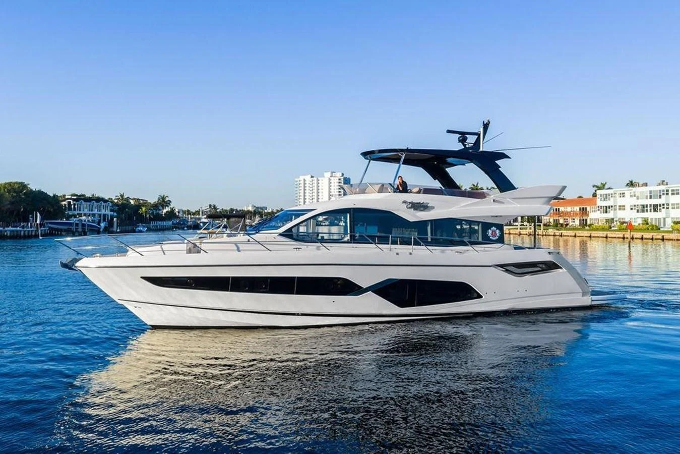A sleek and modern yacht cruising on calm waters with a clear blue sky backdrop. aboard ELLIGANCE Yacht for Sale