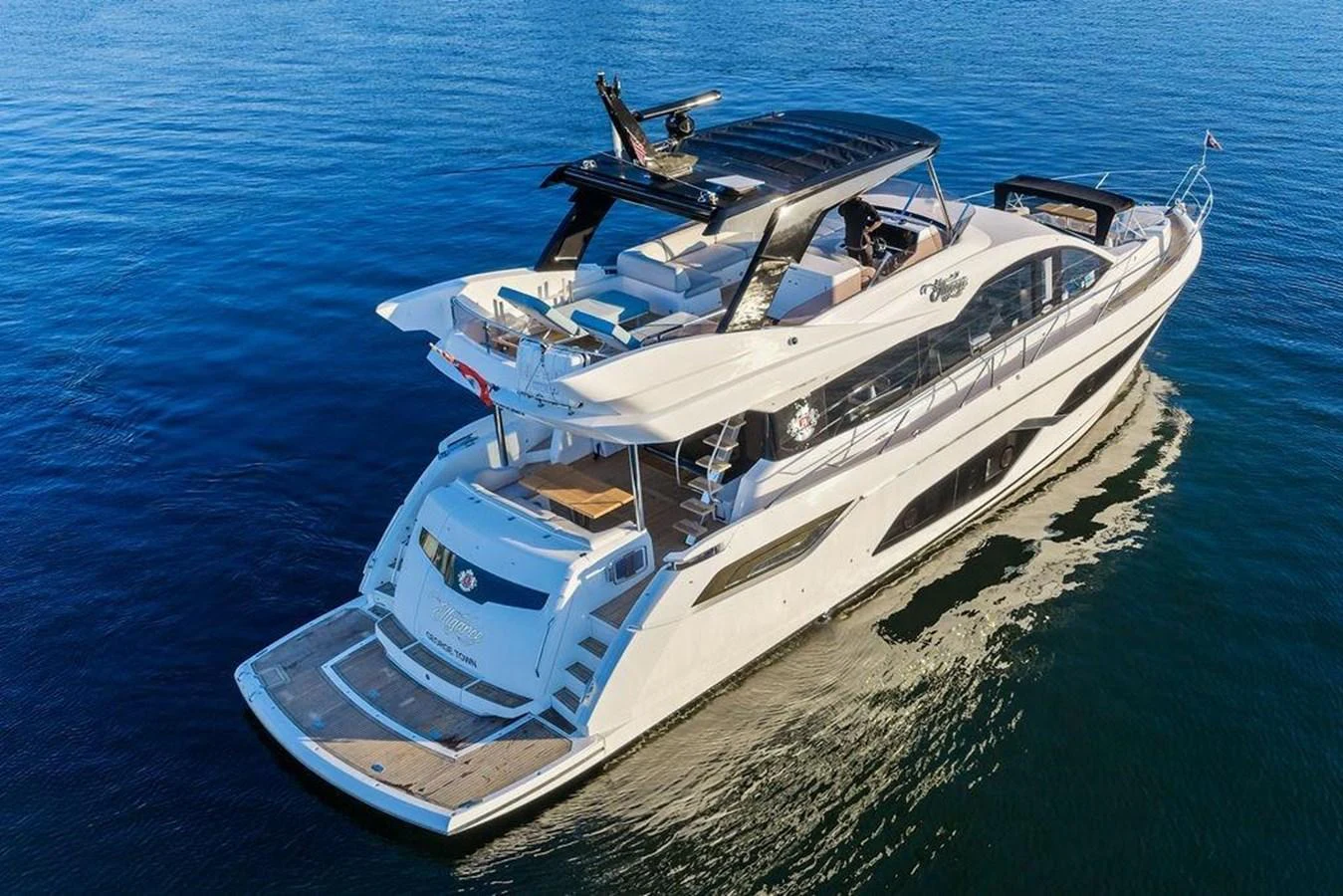 A sleek yacht glides gracefully on calm waters, showcasing its modern design and spacious deck areas. aboard ELLIGANCE Yacht for Sale