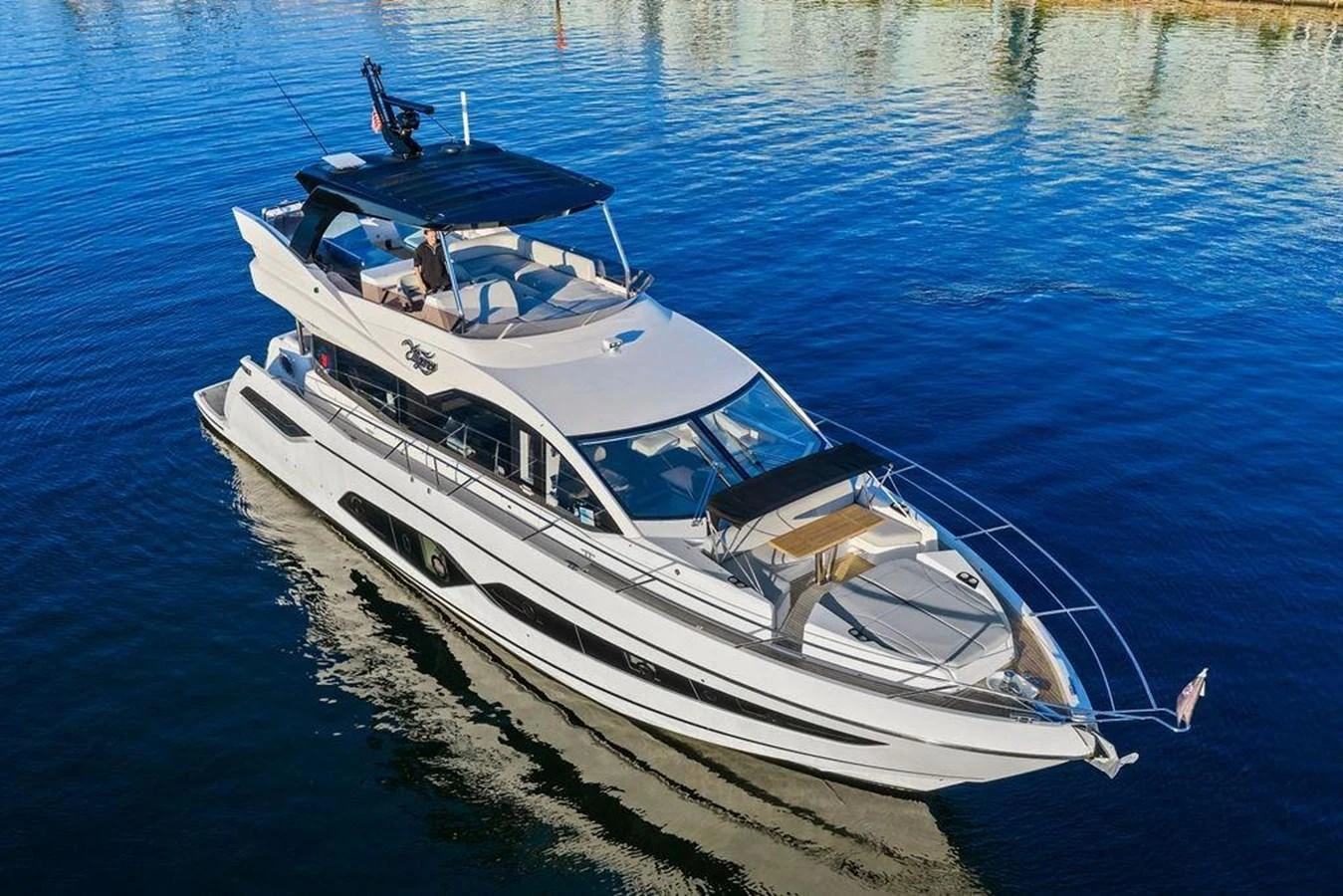 A sleek and modern yacht glides gracefully on calm waters, showcasing its elegant design and spacious deck areas. aboard ELLIGANCE Yacht for Sale