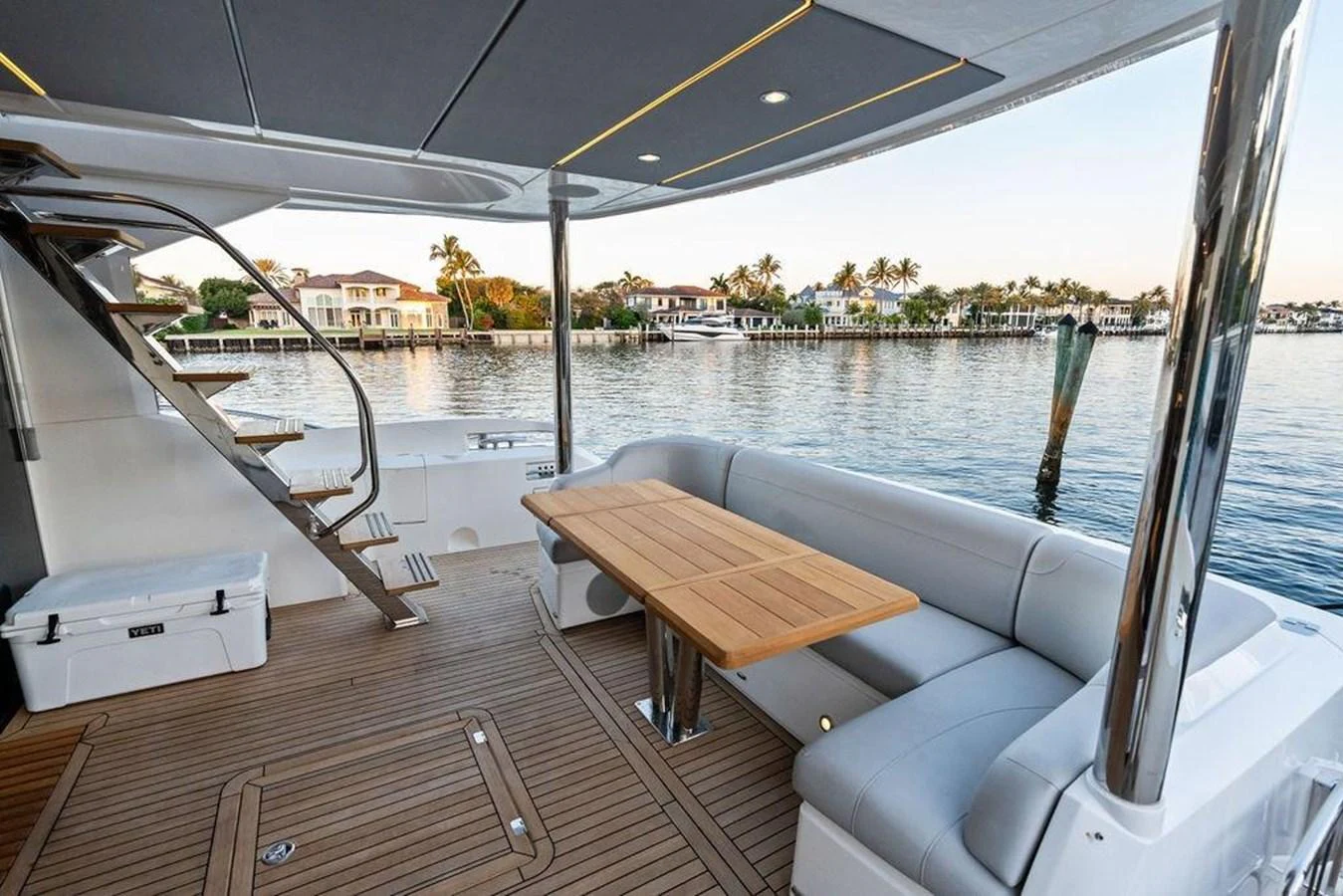 The aft deck features a comfortable seating area with a wooden table, perfect for outdoor dining and relaxation. aboard ELLIGANCE Yacht for Sale