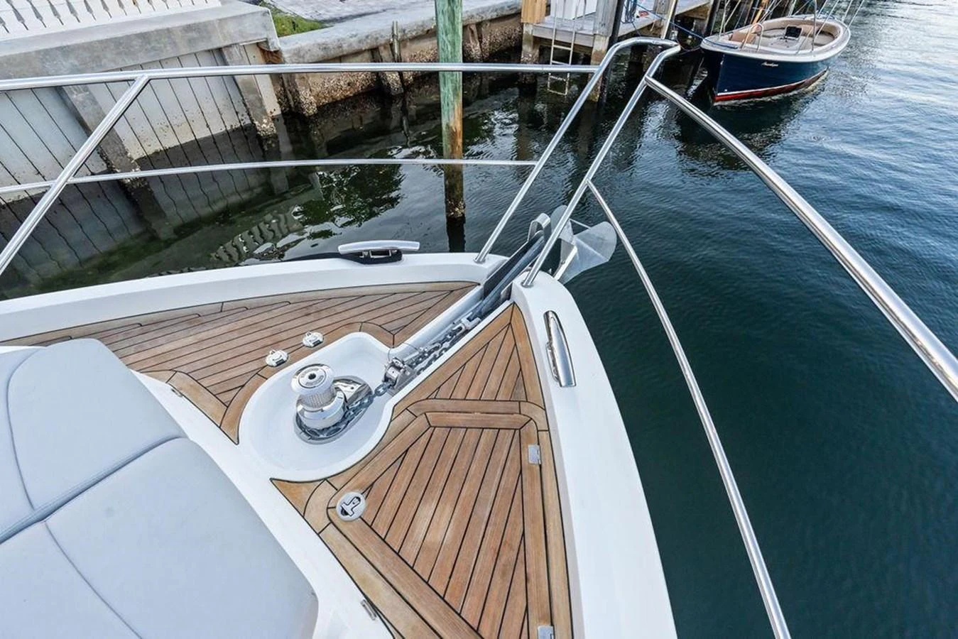 The image showcases the bow of a yacht with a focus on the anchor mechanism and teak decking. aboard ELLIGANCE Yacht for Sale