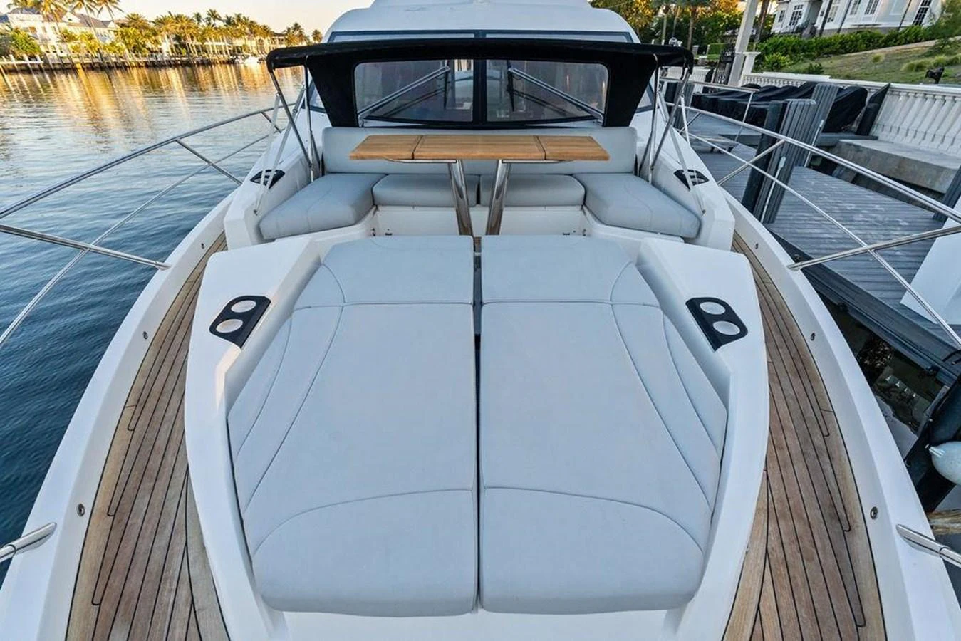 The yacht's foredeck features spacious sunpads and a stylish seating area with a wooden table. aboard ELLIGANCE Yacht for Sale