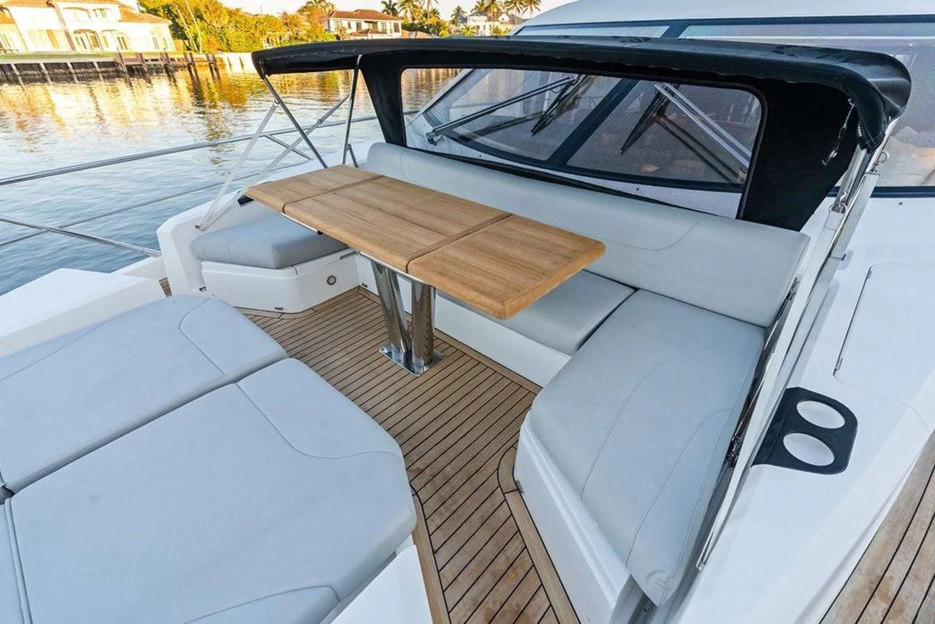 The aft deck features comfortable seating and a wooden dining table, perfect for outdoor relaxation and dining. aboard ELLIGANCE Yacht for Sale