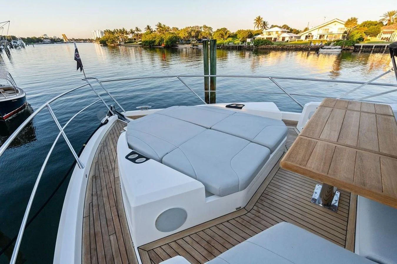 The foredeck features a spacious sunbathing area with plush cushions and a wooden table, perfect for relaxation and dining. aboard ELLIGANCE Yacht for Sale