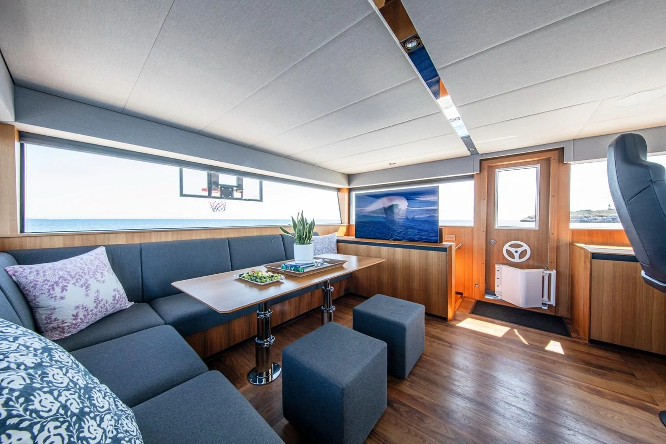 The salon features a spacious seating area with modern furnishings and ample natural light. aboard PLAYA Yacht for Sale