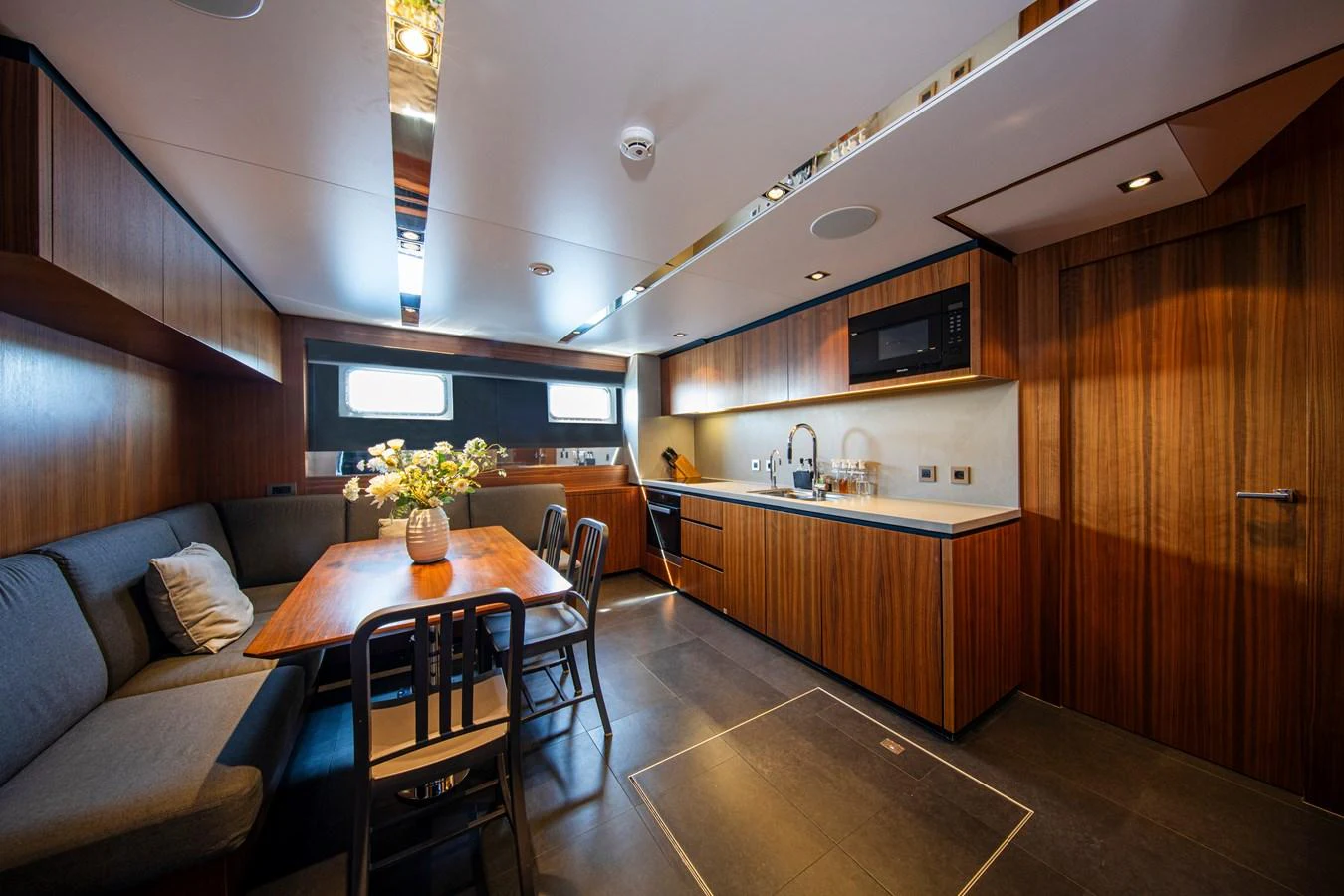 The yacht's galley features a modern design with sleek wood finishes and ample seating. aboard PLAYA Yacht for Sale