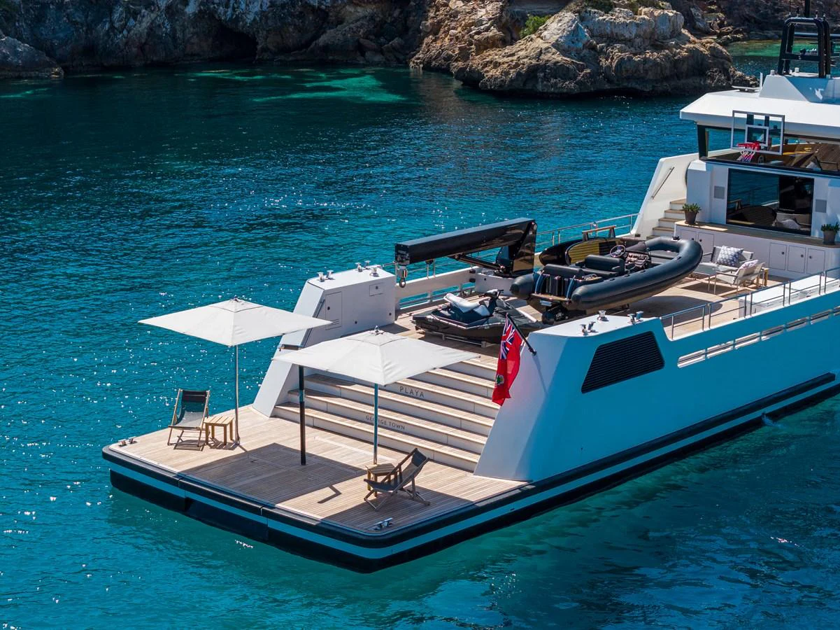 The yacht's aft deck features a spacious lounging area with sun umbrellas and deck chairs, perfect for relaxation. aboard PLAYA Yacht for Sale