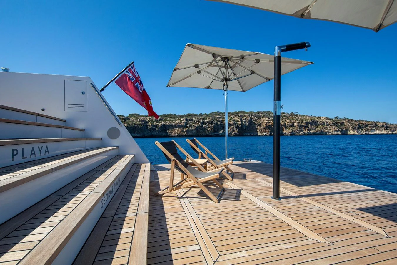 The beach club offers a serene space with sun loungers and umbrellas, perfect for relaxation by the water. aboard PLAYA Yacht for Sale