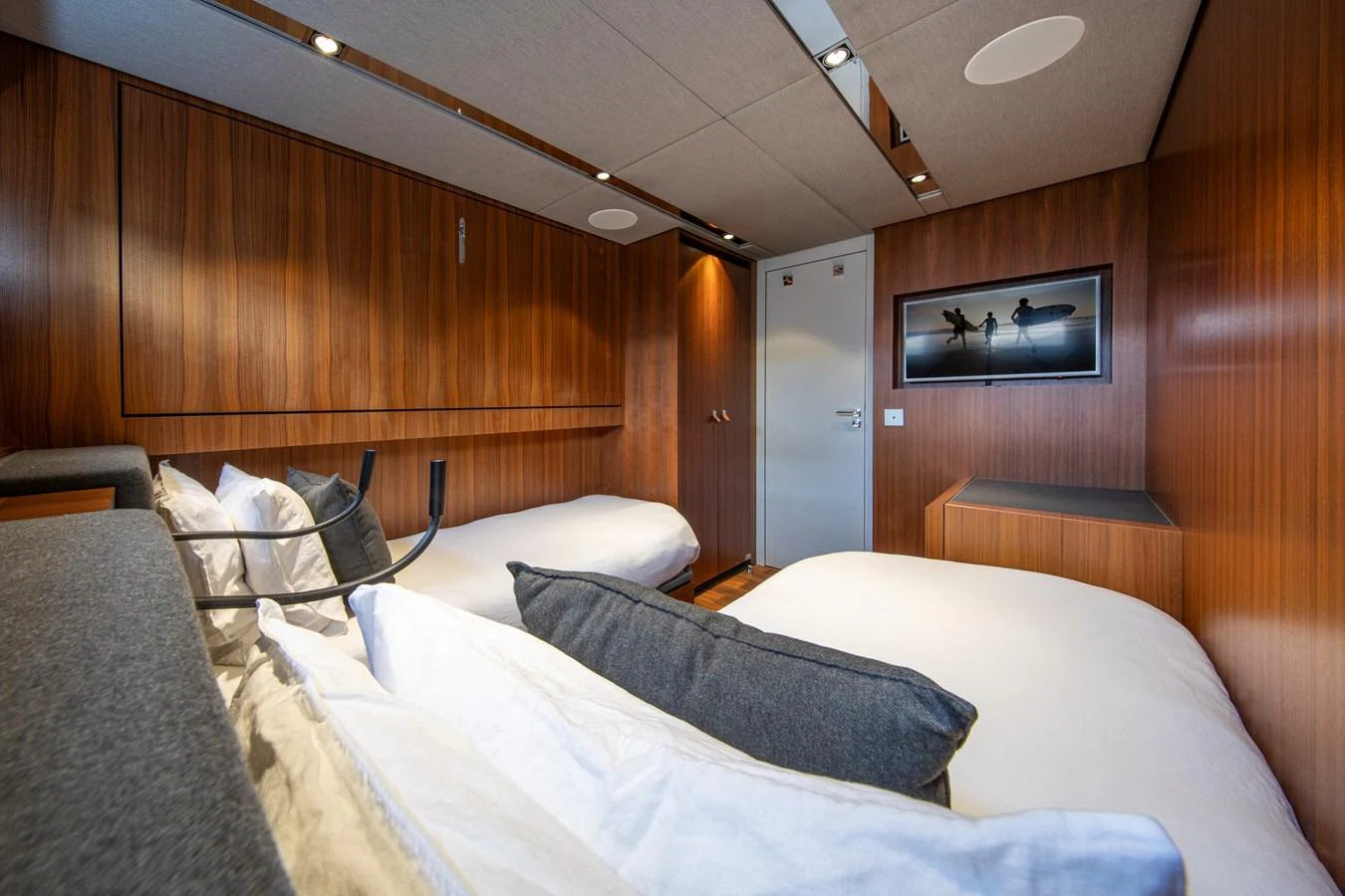 A cozy guest stateroom with twin beds and warm wood paneling. aboard PLAYA Yacht for Sale