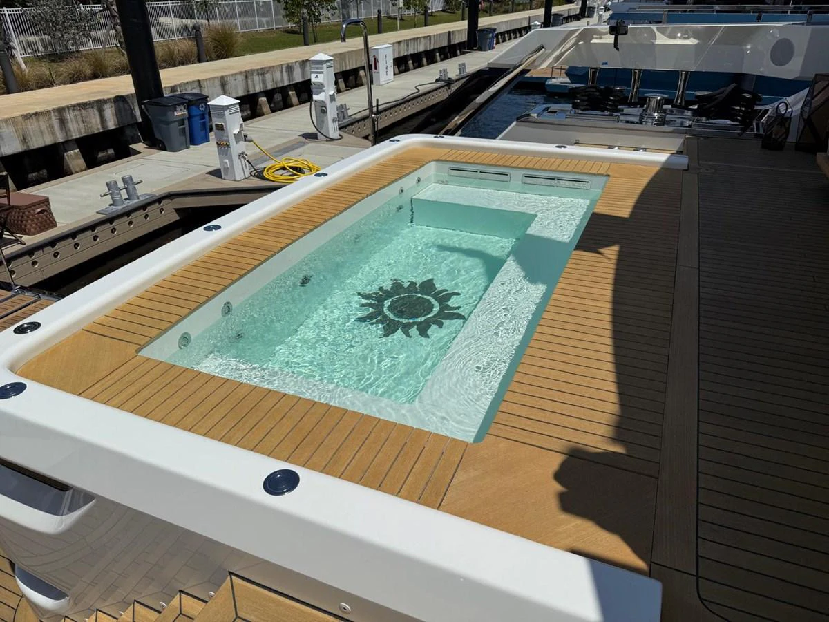 The yacht features a luxurious pool with a sun motif at the bottom, surrounded by a spacious deck. aboard BAGLIETTO DOM 133 #5 Yacht for Sale