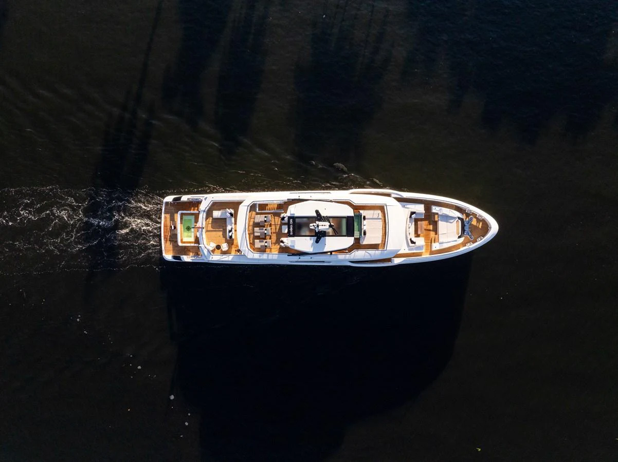An aerial view of a sleek yacht cruising through dark waters, showcasing its elegant design and spacious deck areas. aboard BAGLIETTO DOM 133 #5 Yacht for Sale
